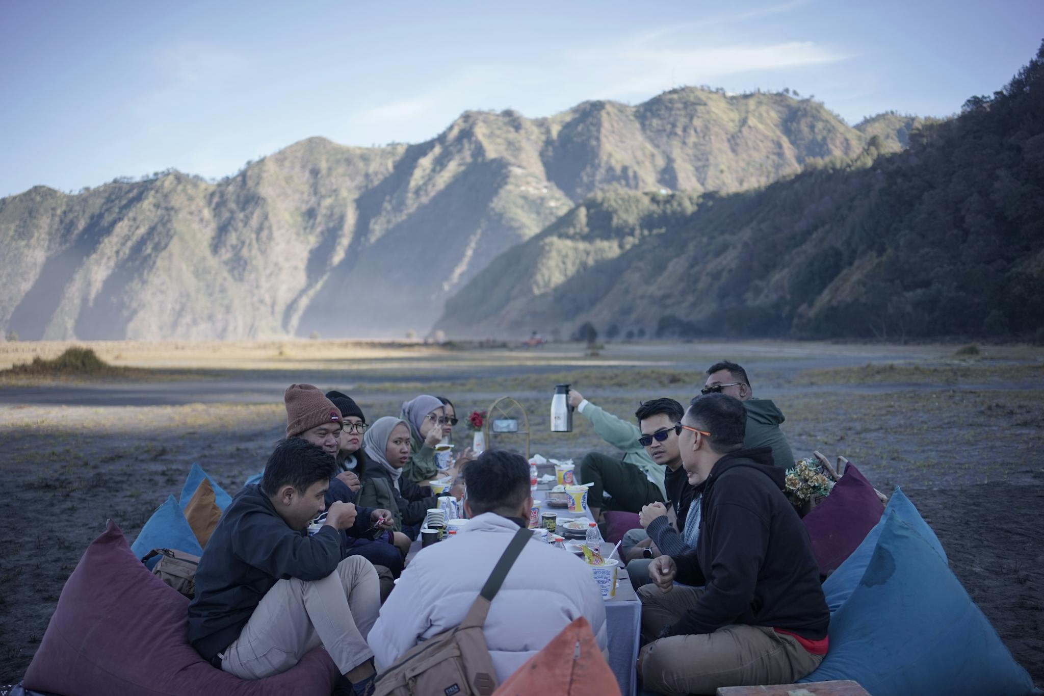 A group of people sitting on bean bags on the beach